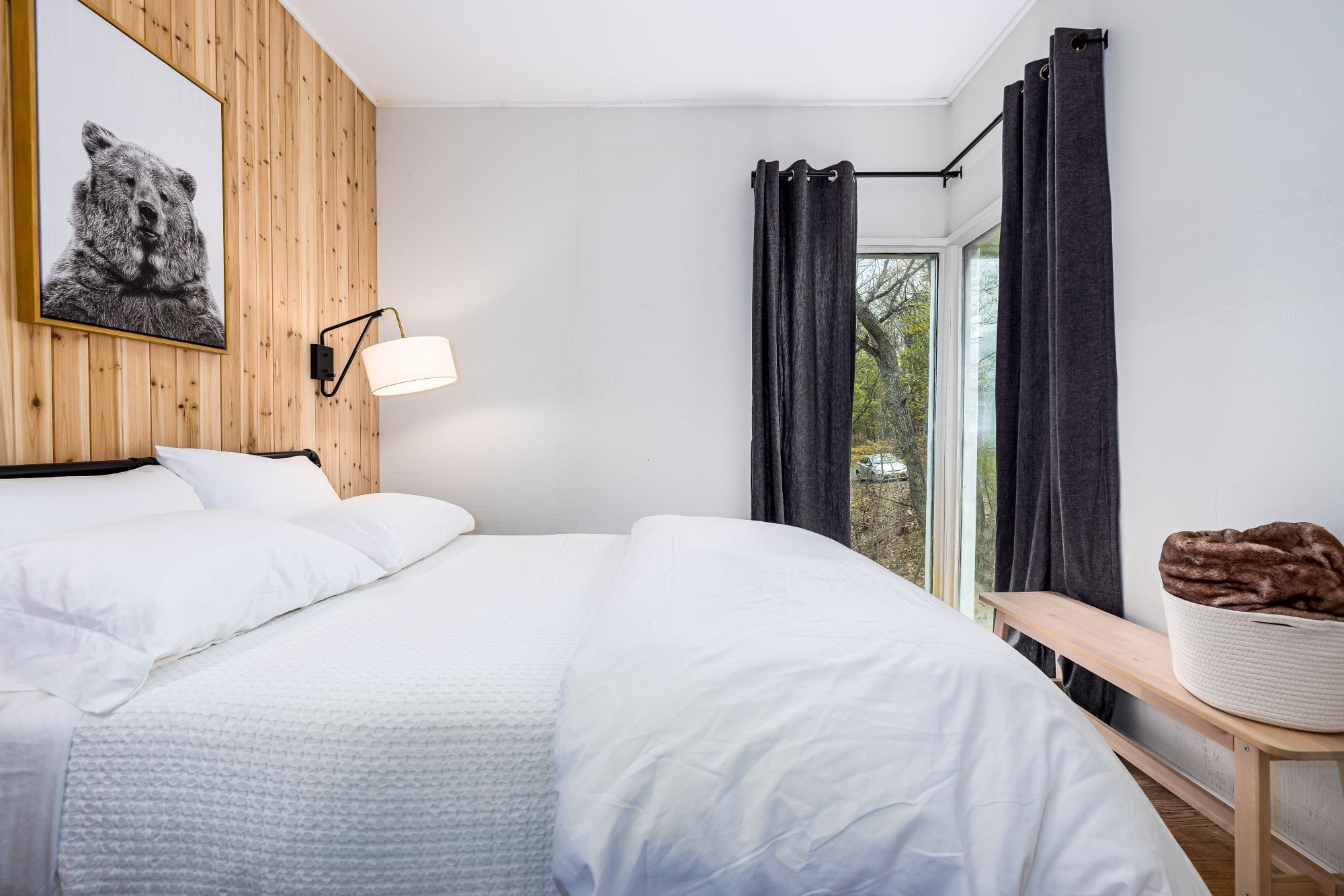 Bright bedroom with a cedar accent wall and a framed bear print