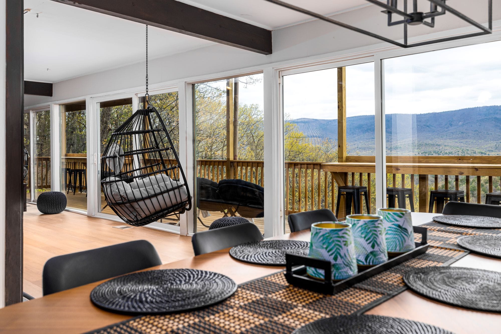 The Chalet dining table set beneath the valley view, open to the deck