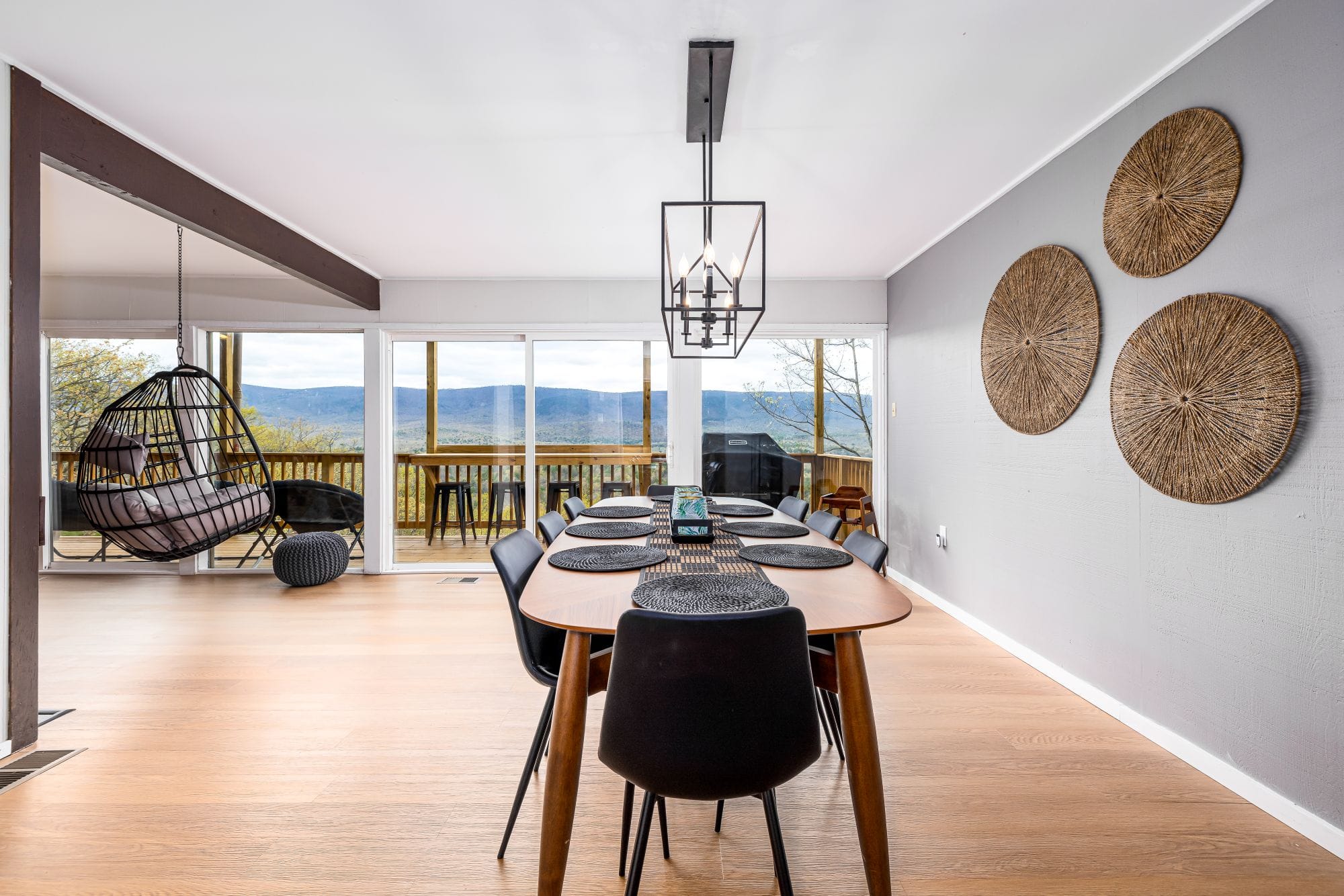 Dining area with a hanging egg chair and the valley through the windows