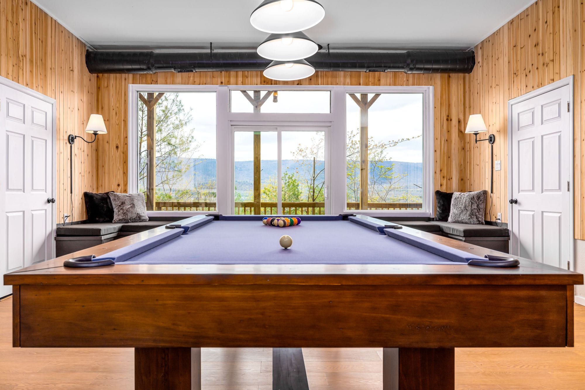 Game room pool table framed by windows over the valley