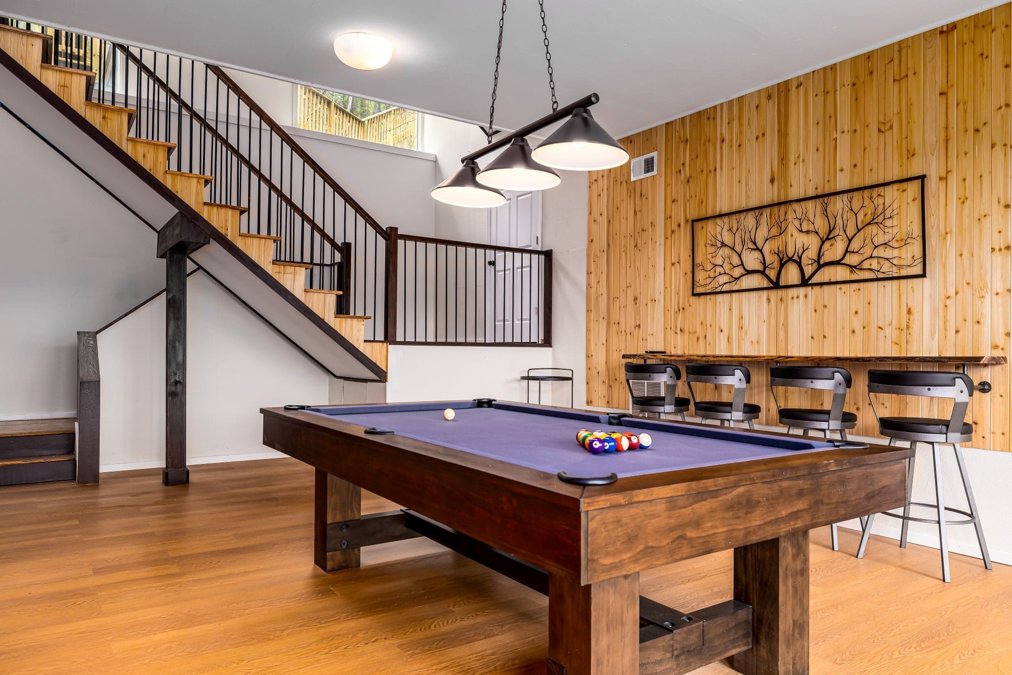 The Chalet game room with a pool table and a bar-height counter with stools along a cedar-plank wall
