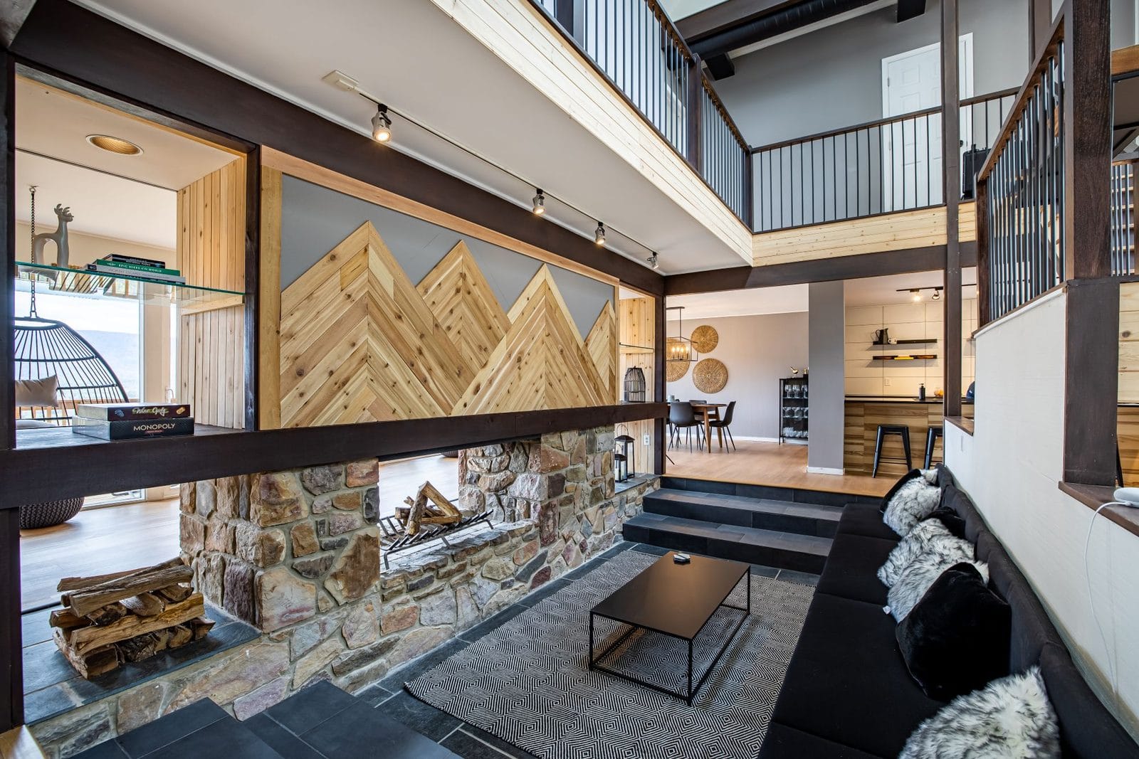 The Chalet sunken great room with a stone fireplace and chevron mountain-wood panel