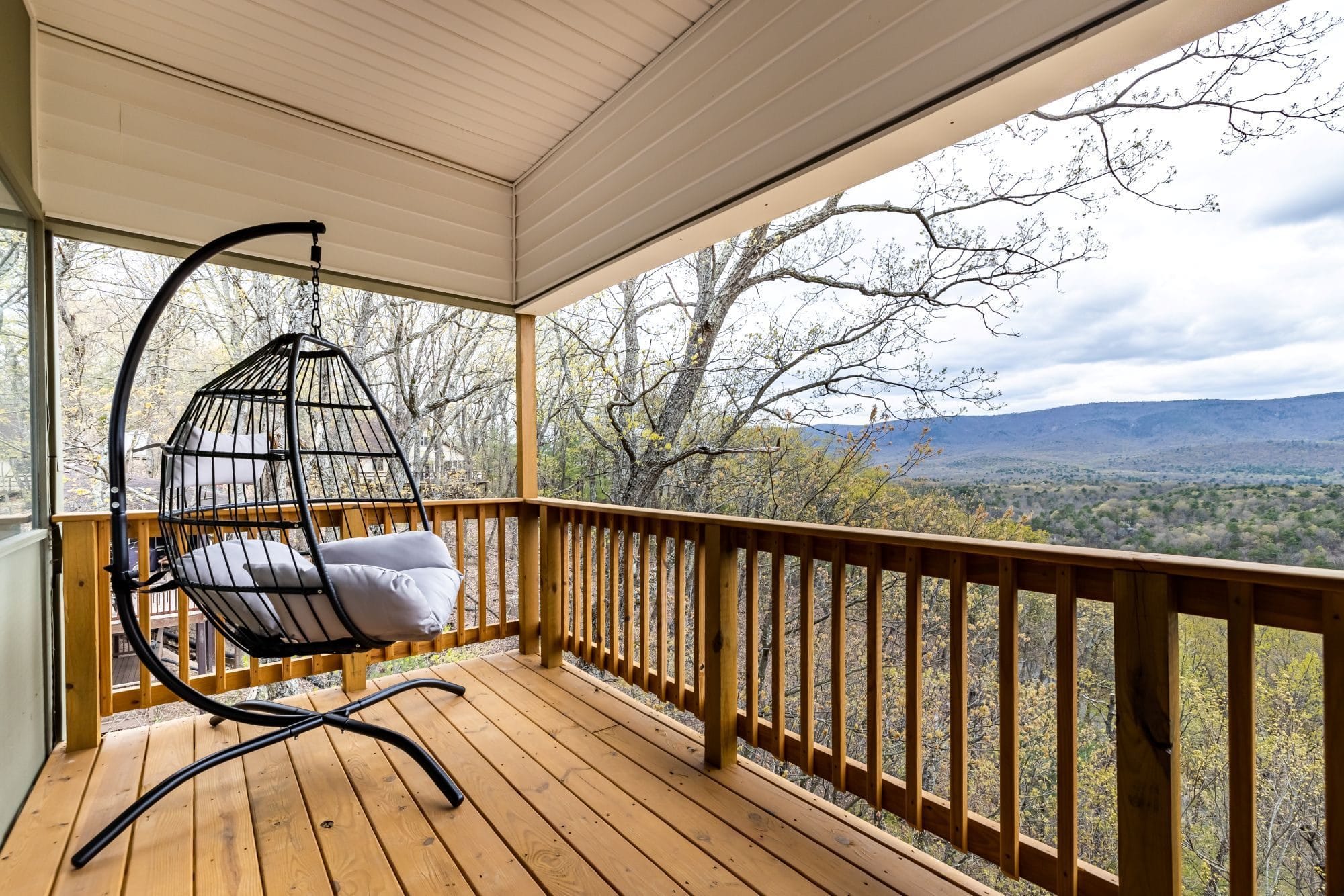 The Chalet's covered deck with a hanging egg chair and the Shenandoah Valley beyond