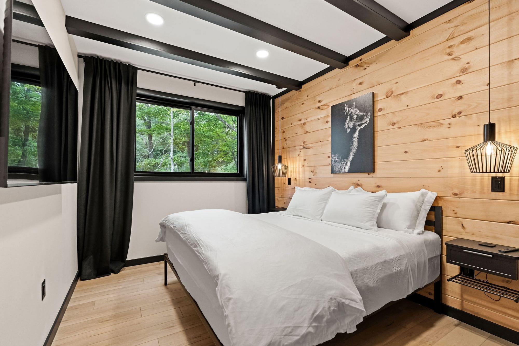 Bedroom with a cedar wall, wolf print, and pendant reading lights