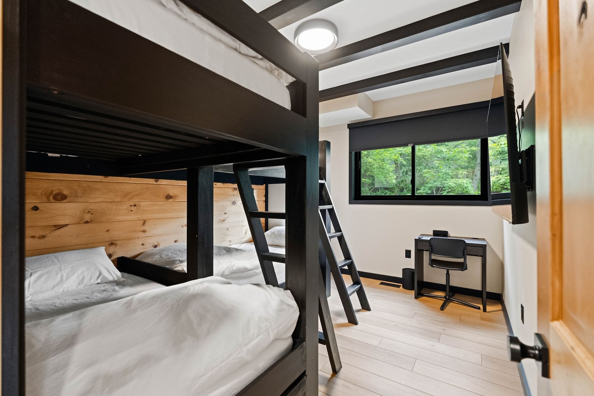 Bunk room with black bunk beds and a desk for kids and extra guests