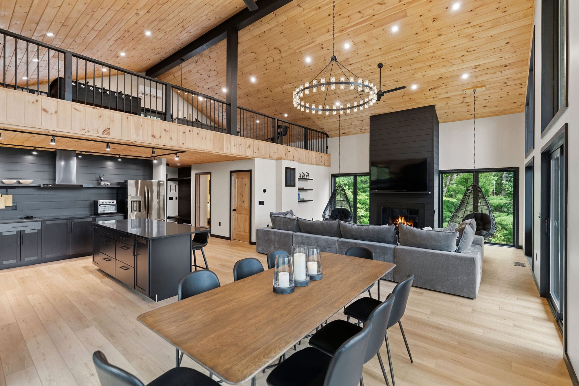 Dining table open to the kitchen, island, and great room under the ring chandelier