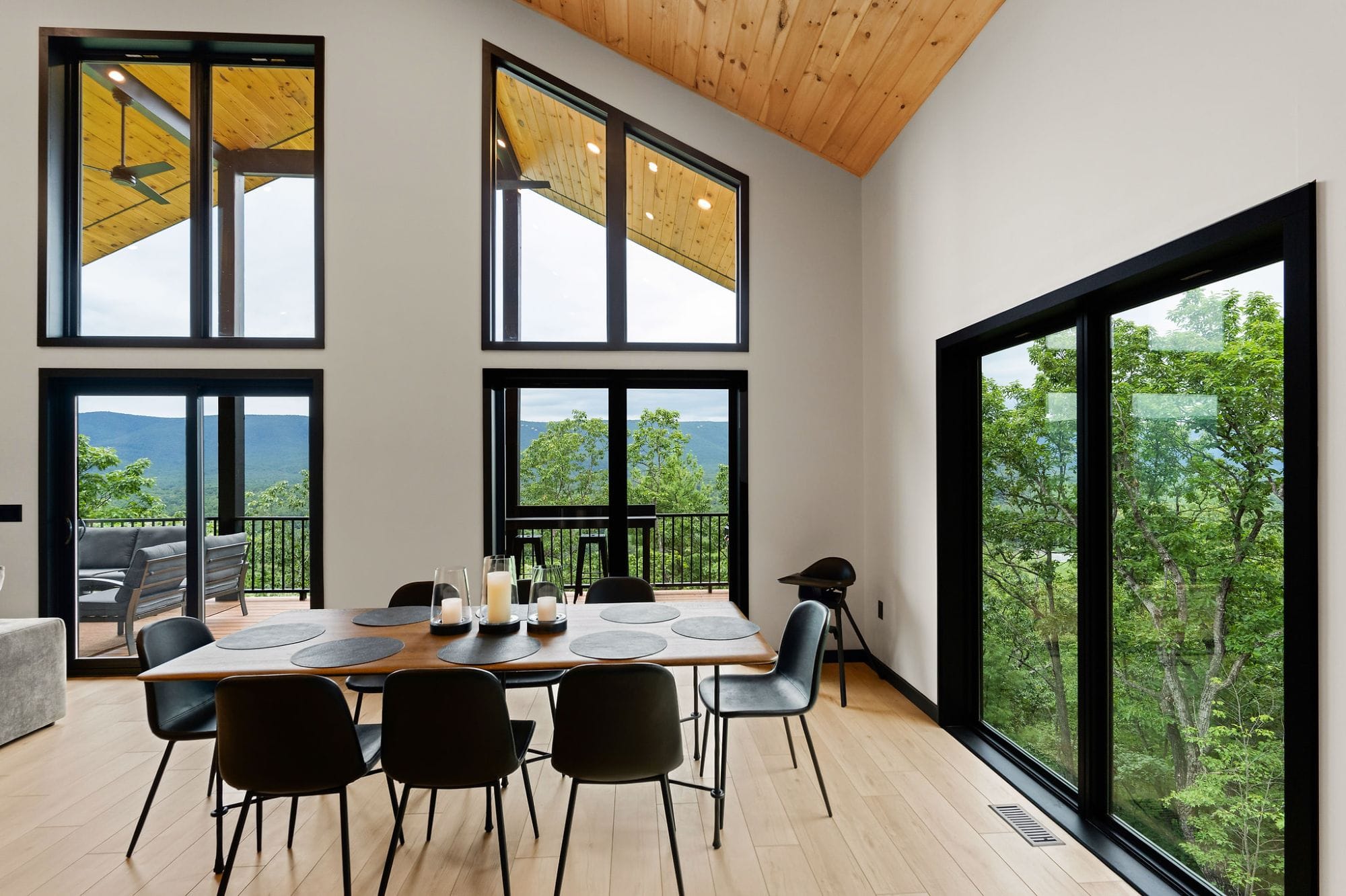 Dining table for eight beneath two-story windows framing the mountains