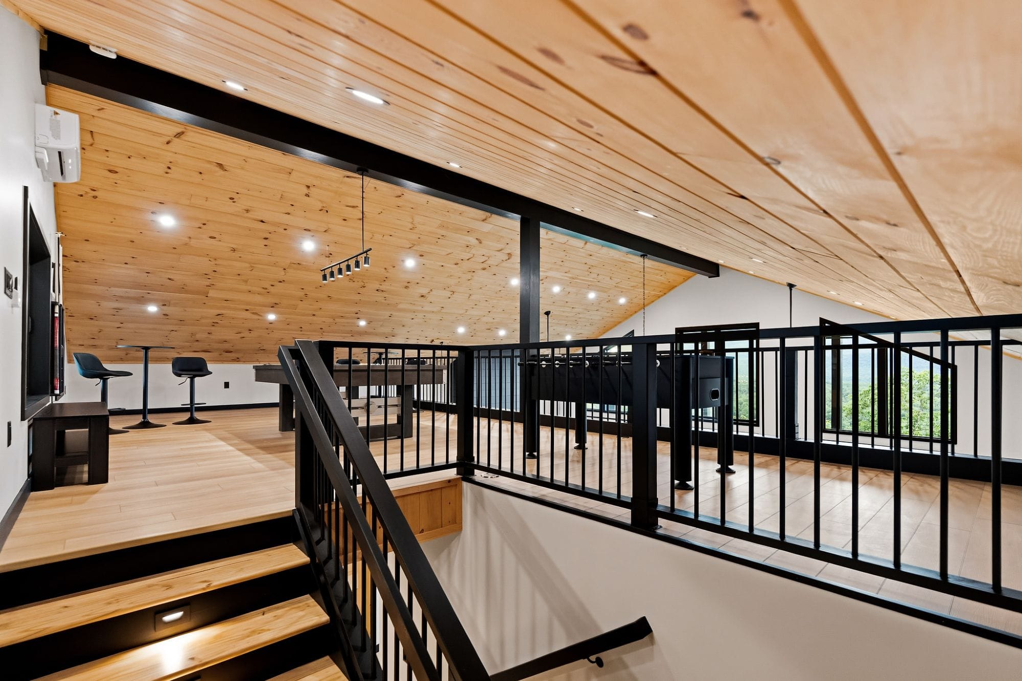 Loft game room overlooking the great room, with bar seating and a TV