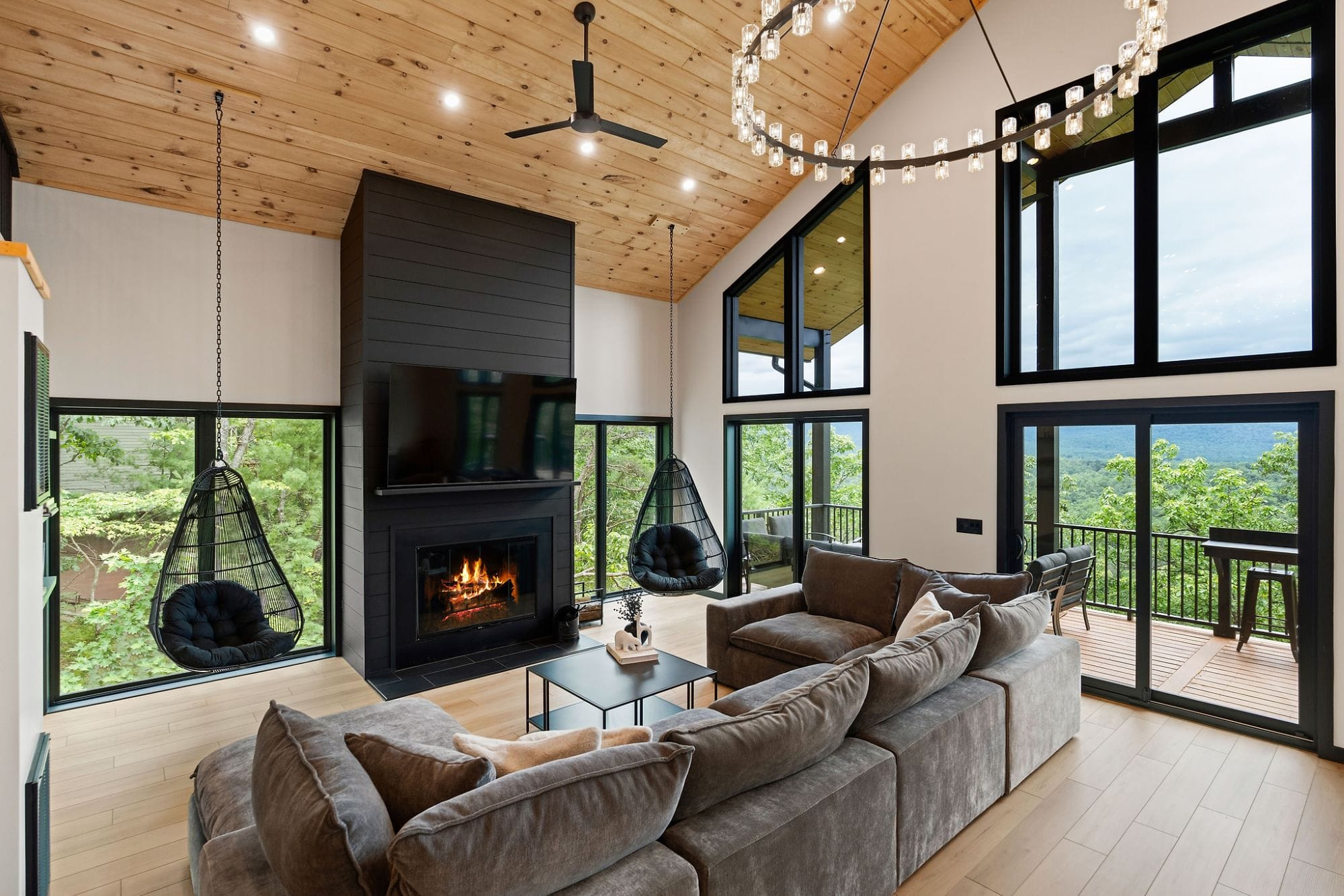 The Cabin great room with a ring chandelier and floor-to-ceiling glass
